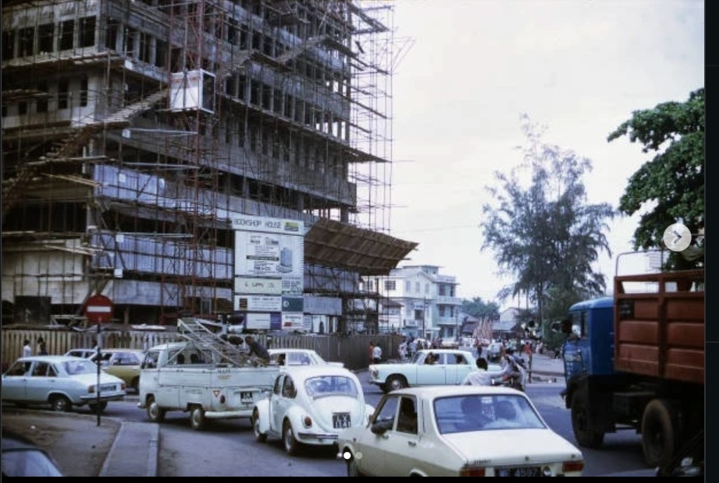 Bookshop House under construction with vintage cars on a busy city street